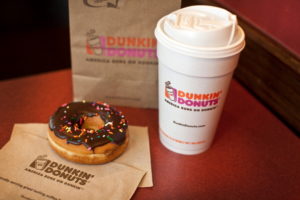 A chocolate glazed donut and a cup of coffee are arranged for a photograph at a Dunkin' Donuts Inc. store in West Orange, New Jersey, U.S., on Thursday, July 7, 2011. Sales at U.S. retailers surpassed analysts' estimates last month as discounts and lower gas prices in the U.S. enticed consumers to spend. Photographer: Emile Wamsteker/Bloomberg via Getty Images